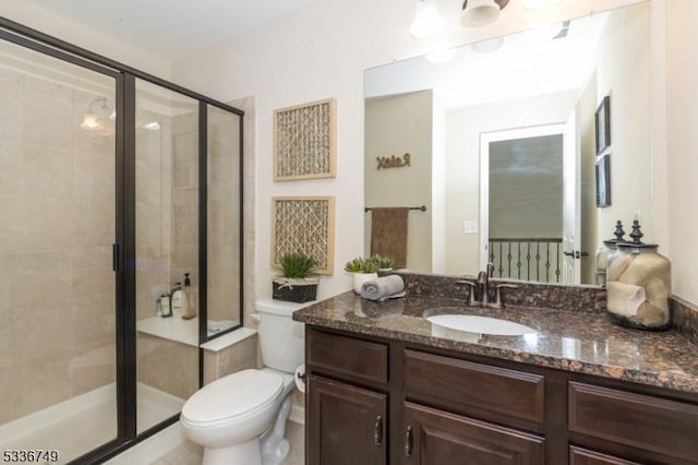 bathroom featuring vanity, toilet, and a shower with shower door