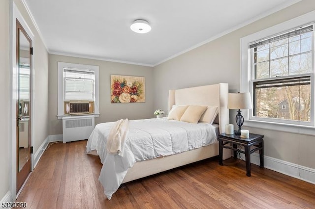 bedroom with crown molding, radiator, hardwood / wood-style floors, and cooling unit