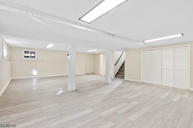 basement with light hardwood / wood-style flooring