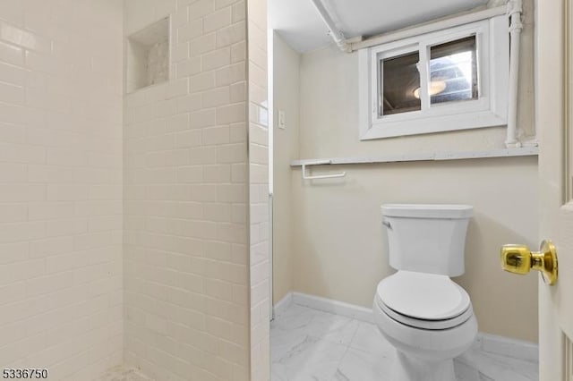 bathroom with toilet and a tile shower