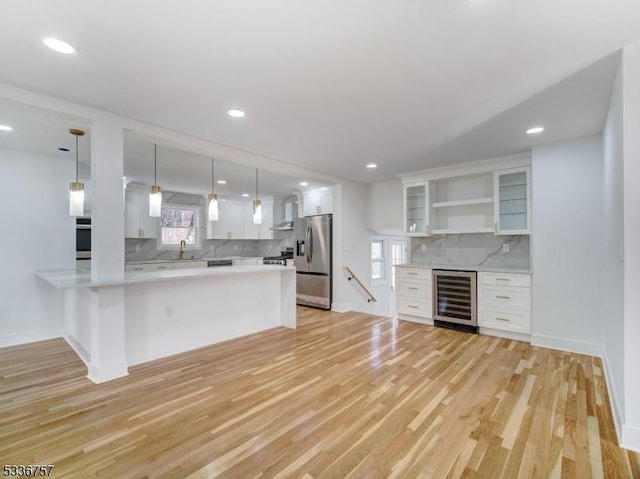 kitchen with wine cooler, white cabinetry, kitchen peninsula, pendant lighting, and stainless steel appliances