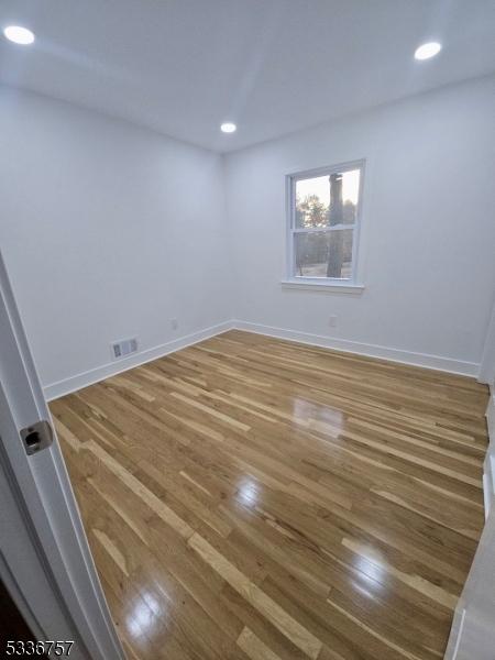 spare room with hardwood / wood-style floors