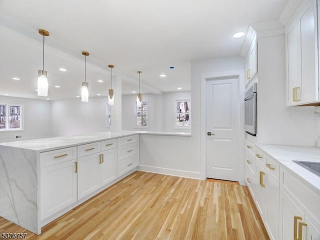 kitchen featuring white cabinetry, pendant lighting, light stone counters, and kitchen peninsula