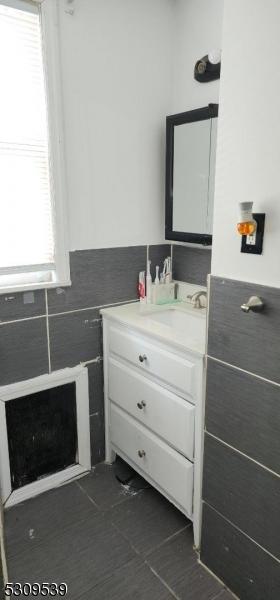 bathroom with vanity and tile walls