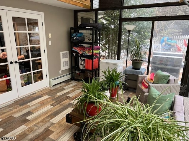 sunroom / solarium featuring a baseboard radiator and french doors