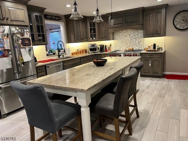 kitchen with dark brown cabinetry, appliances with stainless steel finishes, and a kitchen island