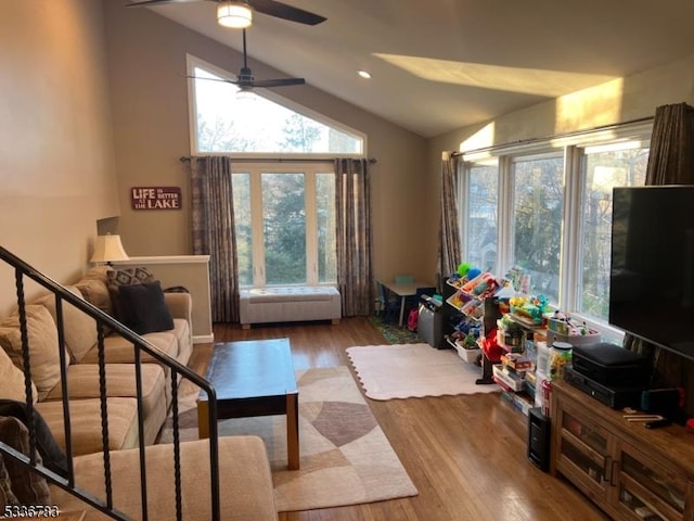 living room featuring ceiling fan, lofted ceiling, and light hardwood / wood-style floors