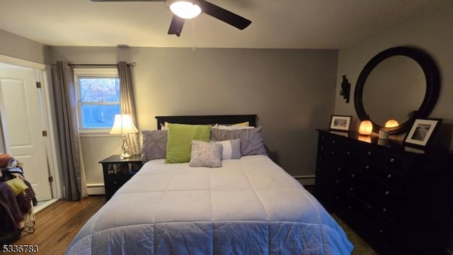 bedroom featuring dark wood-type flooring, ceiling fan, and a baseboard radiator