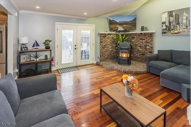 living room featuring french doors, crown molding, hardwood / wood-style floors, and a wood stove