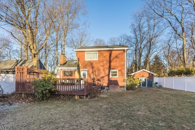 rear view of property with a wooden deck and a yard