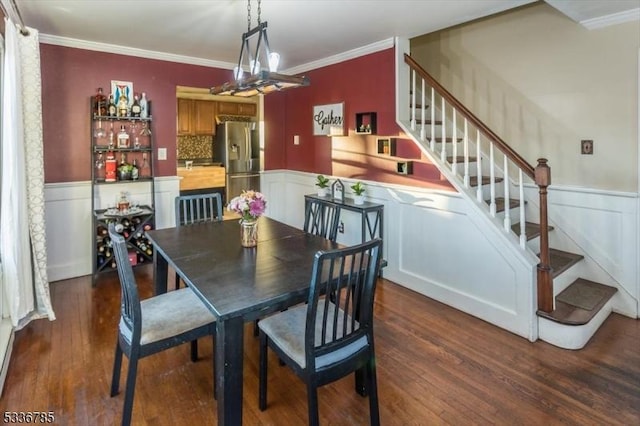 dining area featuring ornamental molding and dark hardwood / wood-style flooring