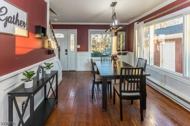 dining area featuring dark hardwood / wood-style flooring, plenty of natural light, ornamental molding, and baseboard heating