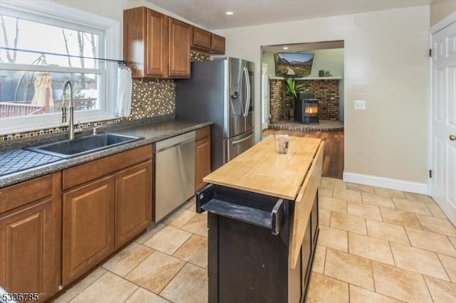 kitchen with light tile patterned flooring, sink, wooden counters, appliances with stainless steel finishes, and backsplash