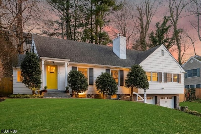 view of front of home with a garage, a yard, a chimney, and roof with shingles