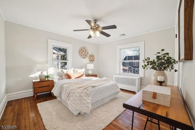 bedroom with crown molding, ceiling fan, radiator, and dark hardwood / wood-style floors