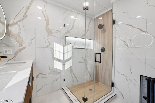 bathroom with tile walls, an enclosed shower, crown molding, and vanity