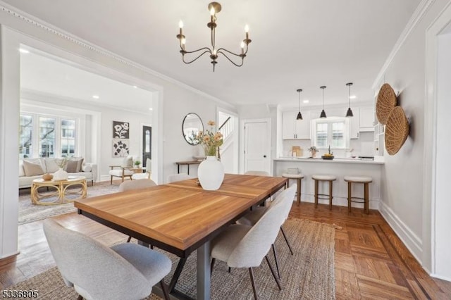 dining area featuring a notable chandelier, plenty of natural light, crown molding, and parquet flooring