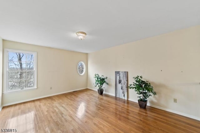 spare room featuring hardwood / wood-style floors and plenty of natural light