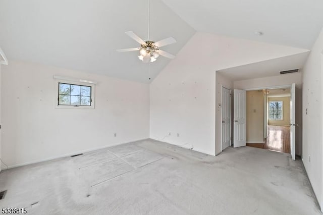 carpeted spare room featuring lofted ceiling and a healthy amount of sunlight