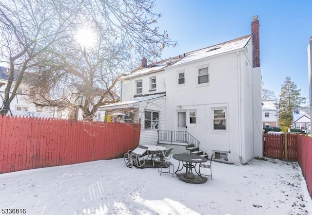 view of snow covered back of property