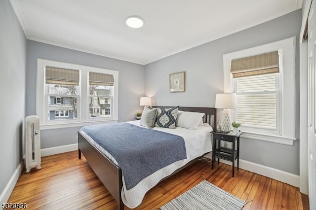 bedroom with crown molding, dark wood-type flooring, and baseboards