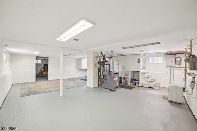 basement featuring a heating unit, visible vents, and stairway