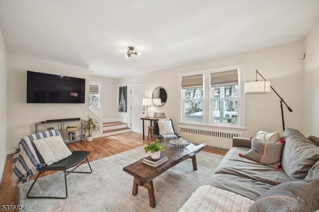 living area featuring radiator, light wood-type flooring, and plenty of natural light