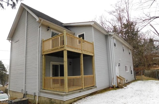 rear view of house with central AC unit and a balcony