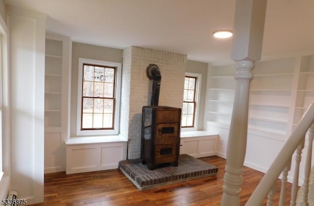 details with wood-type flooring, built in features, and a wood stove