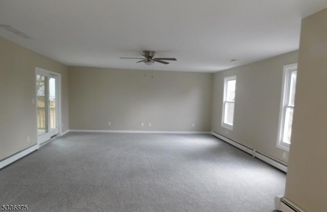 carpeted spare room featuring baseboard heating and ceiling fan