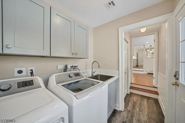 laundry room with sink, a baseboard heating unit, cabinets, independent washer and dryer, and dark hardwood / wood-style flooring