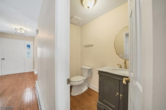 bathroom with baseboard heating, vanity, toilet, and hardwood / wood-style flooring