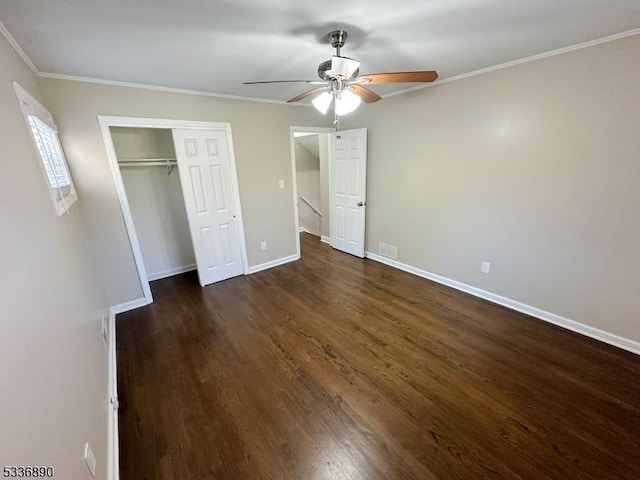 unfurnished bedroom featuring dark wood-type flooring, ornamental molding, a closet, and ceiling fan