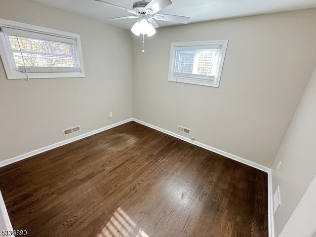 spare room featuring dark wood-type flooring and ceiling fan