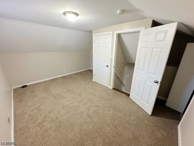 additional living space featuring vaulted ceiling and carpet floors