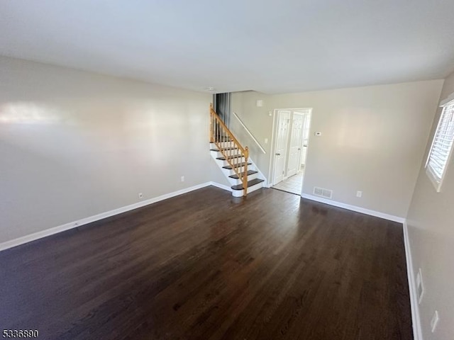 unfurnished room with dark wood-type flooring