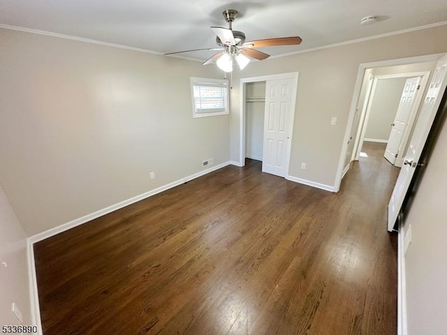 unfurnished bedroom with crown molding, ceiling fan, dark hardwood / wood-style flooring, and a closet