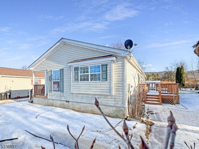 view of snowy exterior featuring a deck