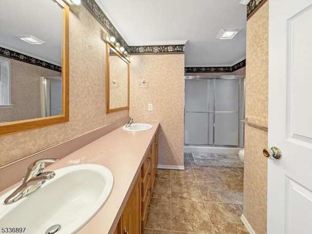 bathroom with a shower with door, vanity, ornamental molding, and toilet