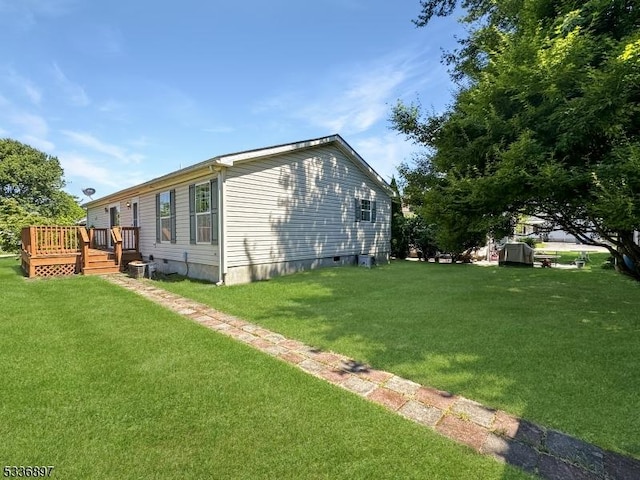 view of side of property with a deck and a lawn