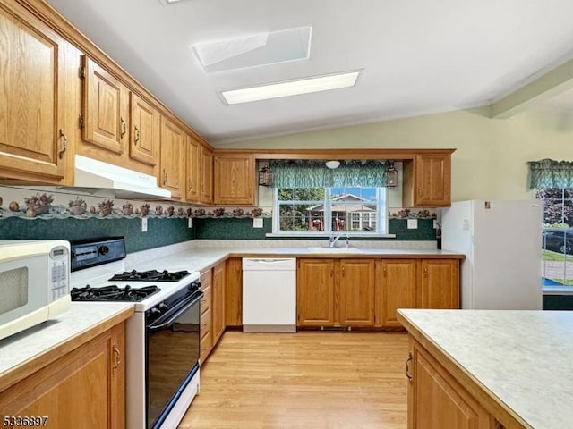 kitchen with tasteful backsplash, lofted ceiling, sink, light hardwood / wood-style floors, and white appliances