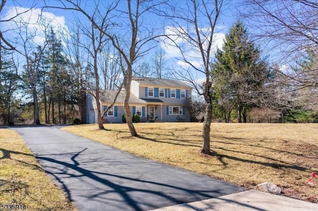 view of front of home with a garage, driveway, and a front lawn