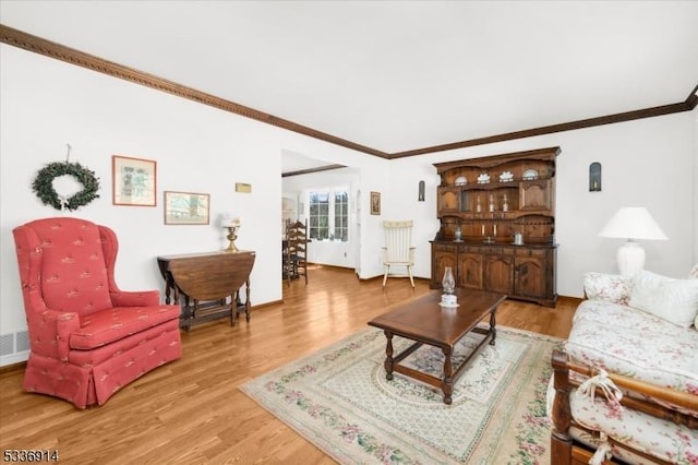 living room with light wood-style floors and ornamental molding