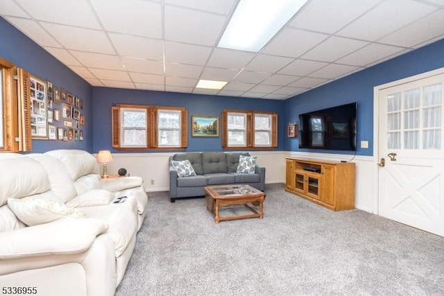 living room with light colored carpet and a drop ceiling