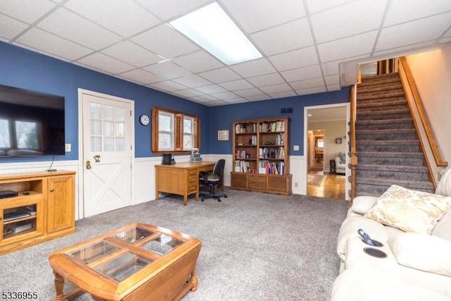 carpeted living room featuring a paneled ceiling