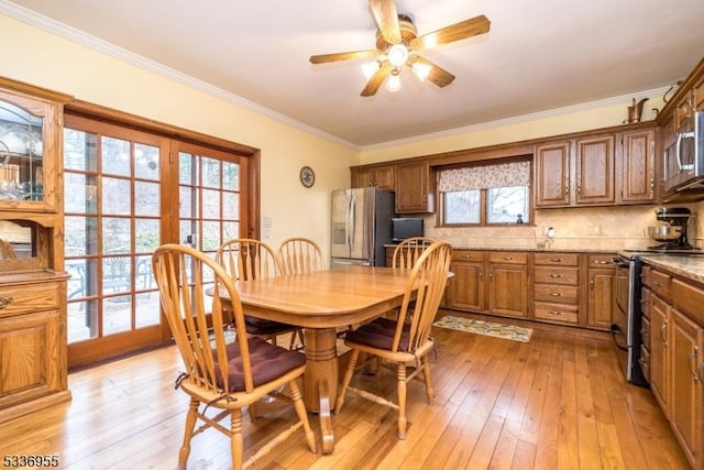 dining space featuring crown molding, ceiling fan, and light hardwood / wood-style flooring