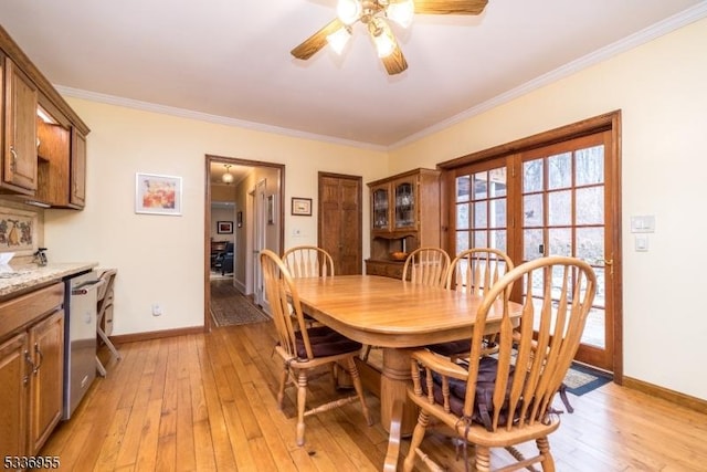 dining space featuring light hardwood / wood-style flooring, ornamental molding, and ceiling fan