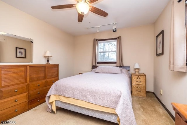 carpeted bedroom featuring rail lighting and ceiling fan