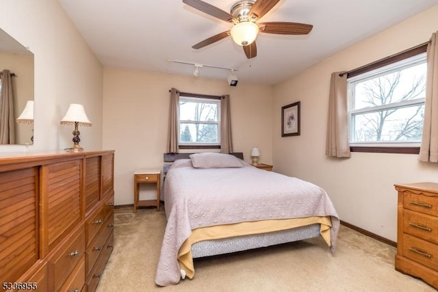 bedroom featuring track lighting, light colored carpet, and ceiling fan