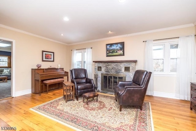 living room with crown molding, a fireplace, and light hardwood / wood-style flooring